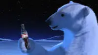 Coca-Colas Anzeige mit einem Eisbären, der eine Flasche Cola genießt.